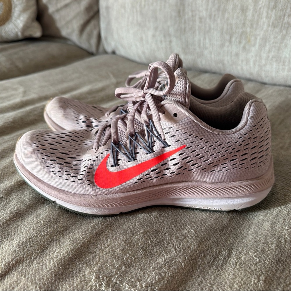 Nike Women's Running Shoes in Light Mauve with a bold Swoosh